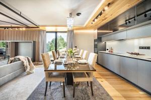 a dining room and kitchen with a table and chairs at Luxury Chalets Lesná in Nová Lesná