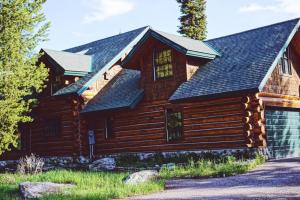 una baita di tronchi con tetto a foglie d'azzardo di Hideout Nature Lodge at Big Sky Resort a Big Sky