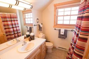 un bagno con lavandino, water e finestra di Hideout Nature Lodge at Big Sky Resort a Big Sky Altre 35 foto