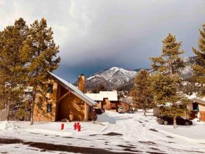 a house in the snow with trees and a mountain at Sky Is The Limit Centrally Located For Big Sky Fun in Big Sky +6 photos