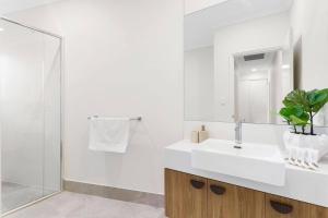 a white bathroom with a sink and a mirror at Spacious and modern Dianella in Perth +32 photos