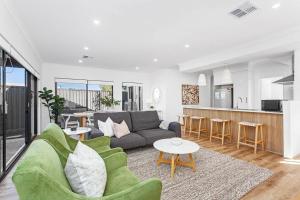 a living room with a couch and a table at Spacious and modern Dianella in Perth