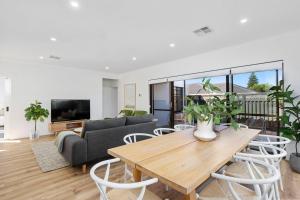 a living room with a table and a couch at Spacious and modern Dianella in Perth