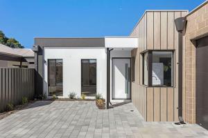 a modern house with a courtyard in front of it at Spacious and modern Dianella in Perth