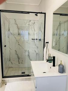 プレトリアにある1 bedroom- The Blyde by Givenのシャワーと白い洗面台を備えたバスルーム +8枚の写真