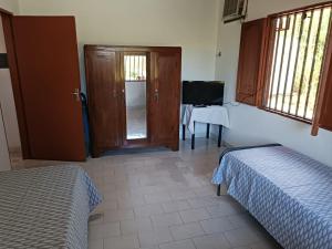 a room with two beds and a door and a table at Quinta Don Tentí in Nu Guazu
