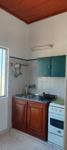 a kitchen with a stove and a sink in it at Quinta Don Tentí in Nu Guazu