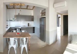a kitchen and dining room with a wooden table and chairs at Oikies High Living Complex in Syvota