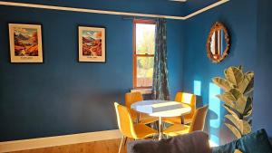 a dining room with blue walls and a table and chairs at Beautiful self contained apartment with garden in Glasgow