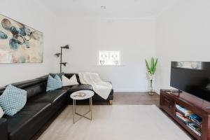 YarravilleにあるNavi Home, stay like localsの黒いソファとテーブルのあるリビングルーム