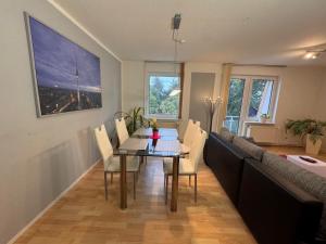 a dining room with a table and a couch at Moderne Wohnungen im Dachgeschoss in Falkensee