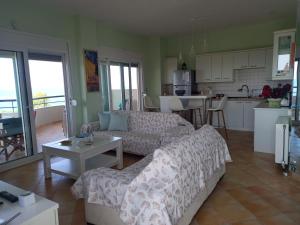 a living room with a couch and a kitchen at Beach house in Nea Potidaea +27 photos