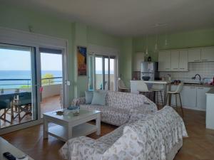 a living room with a couch and a table and a kitchen at Beach house in Nea Potidaea