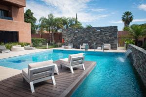 a swimming pool with two chairs and a swimming pool at Neper Hotel in Córdoba