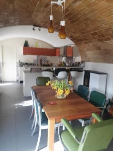 Una cocina y un comedor con mesa y sillas de madera. en Chambre chez l'habitant avec piscine et cuisine d'été, en Saint-Martin-de-la-Brasque