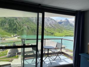 a balcony with a view of a lake and mountains at Vue Lac - Appartement 4 personnes - Tignes le Lac - 803 - Le Palafour in Tignes +3 photos