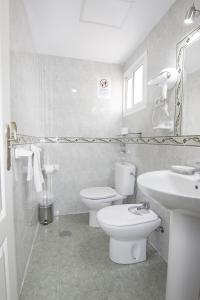 biała łazienka z toaletą i umywalką w obiekcie RentalSevilla Guadalete I w Sewilli +23 zdjęcia