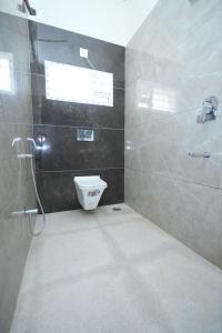 a bathroom with a toilet and a window and a shower at Bhakti Bliss Homestay - New Spacious and luxurious 3BHK with AC, WiFi and Android TV- 5mins From Highway Upto 20 Guests in Tirupati