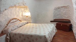 a bedroom with a bed and a suitcase in a room at Alojamiento rural el Fandanguillo in Baza
