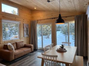 a living room with a table and a couch at Chalet La P'tite Paix in Saint-Alexis-des-Monts