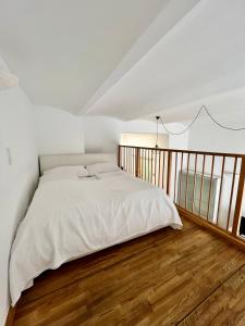 sypialnia z białym łóżkiem i drewnianą podłogą w obiekcie REMA Apartments 1080 w Wiedniu