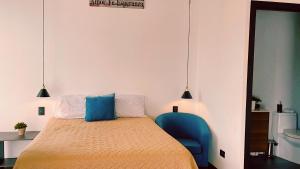 a bedroom with a bed and a blue chair at Apartamento con piscina y jacuzzi Ciudad de Guatemala in Estación Pamplona +14 photos