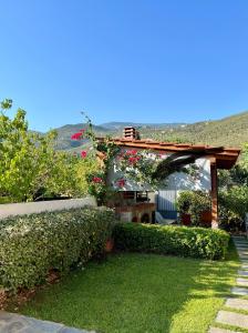 a garden with a pergola with flowers on it at Reven Resort in Kato Gatzea +29 photos