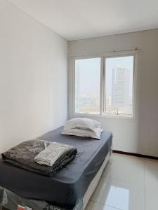 a bed in a white room with a window at Premium Getaway in City Central in Jakarta +24 photos