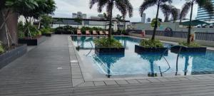 a swimming pool with palm trees in a building at Kristal Place in Manila