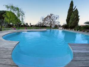 a large pool with blue water in a park at Maison confortable avec piscine près de La Ville-Dieu in La Ville Dieu du  Temple