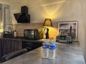 three bottles of water sitting on a counter in a kitchen at Maison Beauté in Tournus +25 photos