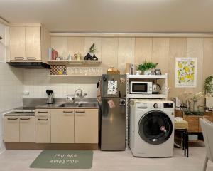 a kitchen with a washing machine and a microwave at Doors Seongsu in Seoul