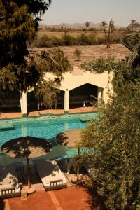 an overhead view of a swimming pool with chairs and trees at Jenan Mayshad Marrakech, Boutique hotel with Pool & Private Padel Court in Marrakech