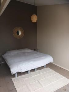 ein Schlafzimmer mit einem weißen Bett und einem Spiegel in der Unterkunft attic apartment in the center in Gouda