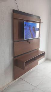 a entertainment center with a tv on a wall at Casa de praia em Japaratinga.(Pé na areia!) in Japaratinga +32 photos