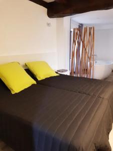 a bed with two yellow pillows on top of it at Appartement charmant à Sare avec vue sur la montagne in Sare