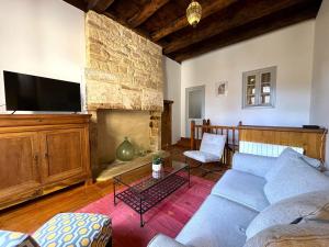 a living room with a couch and a fireplace at Le Secret de St Cyprien in Saint-Cyprien