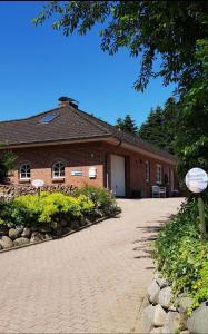 a brick building with a driveway in front of it at Nordsee Ferienwohnung im Künstlerhaus bei Husum - keine Monteure Arbeiter in Oldersbek