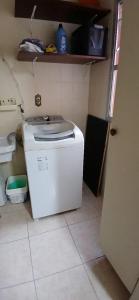 a kitchen with a small white refrigerator in a room at Enseada Malibu perto da praia, lazer e conforto! in Guarujá