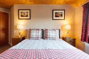 a bedroom with a bed with red and white pillows at Eira's Cottage in Nolton +9 photos