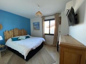 a bedroom with a bed with a blue wall at Maison Pays Basque in Briscous +23 photos