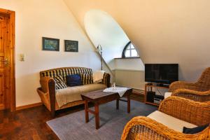 een woonkamer met rieten stoelen en een tv bij Hof Wiesentau in Bösdorf