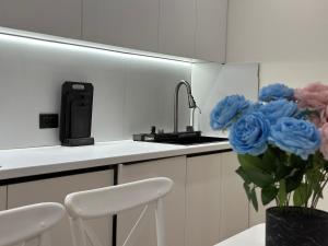 una cucina con lavandino e vaso con rose blu di Двухкомнатной квартиры с раздельными спальнями центре Атырау ЖК Ayagoz a Atyraū