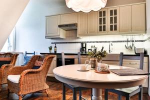 een keuken met een tafel en stoelen en een keuken met witte kasten bij Hof Wiesentau in Bösdorf