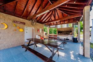 eine Terrasse mit einem Holztisch und Bänken in der Unterkunft La Querencia in Villa Carlos Paz