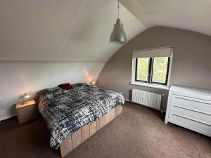 a bedroom with a bed and a window at Bungalow Vlier | 6 personen - Vakantiepark De Kremmer in Gasselte