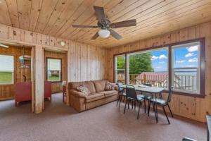 - un salon avec un ventilateur de plafond, une table et des chaises dans l'établissement TB6 Thunder Bay Resort Cabin 6, à Phelps