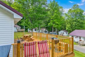 une terrasse en bois avec deux chaises et une table de pique-nique dans l'établissement TB6 Thunder Bay Resort Cabin 6, à Phelps
