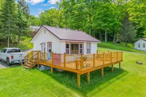 une petite maison blanche avec une grande terrasse dans l'établissement TB6 Thunder Bay Resort Cabin 6, à Phelps 5 autres photos