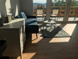 a living room with a couch and a table and a balcony at Panorama Wooden Cabin - Hot Tub in Szentendre